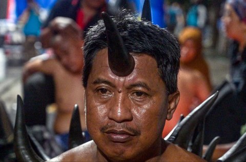 Seorang pria menjalani terapi bekam menggunakan tanduk sapi, yang disediakan oleh para relawan di tenda sementara yang didirikan untuk menampung keluarga santri yang hilang di Rumah Sakit Bhayangkara, Surabaya, Minggu (05/10/2025) malam.