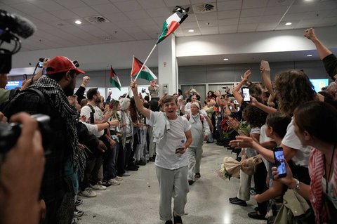 Seorang aktivis mengibarkan bendera Palestina saat tiba di Bandara Internasional Eleftherios Venizelos di Athena, Yunani, Senin, (06/10/2025) waktu setempat