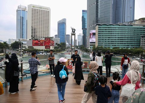 Warga mengantre untuk berfoto di Anjungan Halte Transjakarta Bundaran HI Astra, Jakarta, selama libur peringatan Isra Mikraj, Senin (27/1/2025).