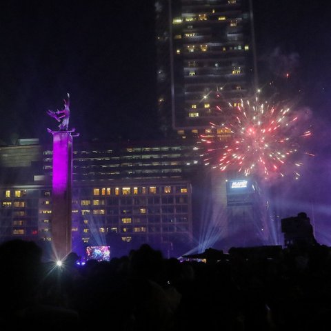 Atraksi formasi drone dan 'video mapping' mewarnai malam pergantian tahun di kawasan Bundaran Hotel indonesia (HI), Jakarta, Senin (1/1/2024). Selain atraksi formasi drone, perayaan Tahun baru 2024 yang dihadiri ribuan warga di lokasi tersebut juga diwarnai atraksi 'water mist', 'video mapping', serta kembang api.Liputan6.com/Angga Yuniar