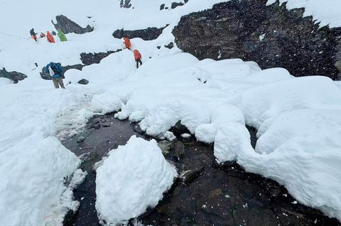 Para pendaki berjalan  di tengah salju tebal di kamp Tangxiang di Lembah Karma, Tibet, Minggu (05/10/2025).