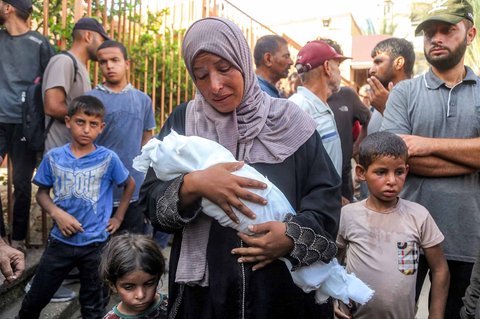 Ibu Yahya Fadi al-Najjar, seorang bayi yang meninggal dunia akibat kekurangan gizi, berduka sambil memegang jenazah anaknya di Kompleks Medis Nasser di Khan Yunis, Jalur Gaza selatan, Minggu, (20/07/2025).