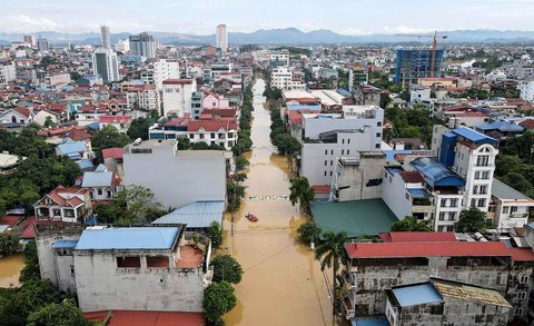 Pemandangan udara ini menunjukkan tim penyelamat di atas perahu (tengah) bergerak di sepanjang jalan yang terendam banjir setelah hujan lebat yang dibawa oleh Topan Matmo di kota Thai Nguyen,Vietnam, Rabu (08/10/2025).