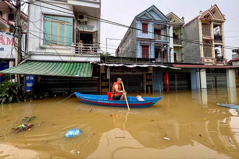 Seorang pria mendayung kano melewati genangan air melewati gedung-gedung di komune That Khe yang terendam banjir setelah hujan deras akibat Topan Matmo di Provinsi Lang Son Vietnam, Rabu (08/10/2025).