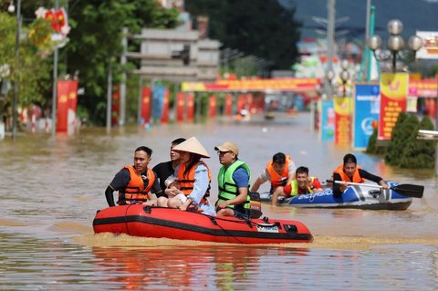 Warga setempat menggunakan perahu di jalanan yang terendam banjir akibat Topan Matmo di Thai Nguyen, Vietnam, Rabu (08/10/2025).