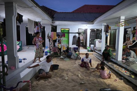 Satu keluarga duduk di bak pasir di rumahnya di Desa Legung Timur, Sumenep, Pulau Madura, Indonesia, Selasa (09/09/2025).