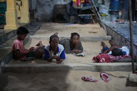 Warga berbaring di bak pasir yang tersedia di hampir setiap rumah di Desa Legung Timur, Sumenep, Pulau Madura, Indonesia, Selasa (09/09/2025).