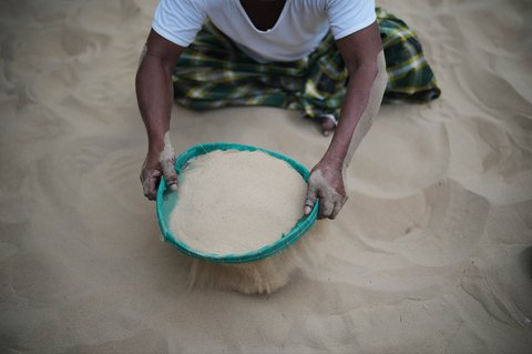Warga menggunakan saringan untuk membersihkan pasir di Desa Legung Timur, Sumenep, Pulau Madura, Indonesia, Selasa (09/09/2025).