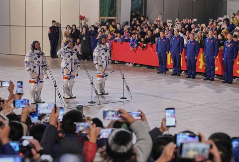 Astronot China  untuk misi Shenzhou 21, Zhang Lu (tengah), memberi hormat di samping rekan-rekannya, Zhang Hongzhang (kiri), dan Wu Fei, saat menghadiri upacara pelepasan misi luar angkasa berawak mereka di Pusat Peluncuran Satelit Jiuquan di Tiongkok barat laut, Jumat, (31/10/2025).