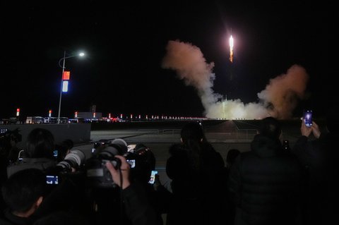 Para jurnalis merekam roket Long March 2F China yang membawa tiga astronaut untuk misi luar angkasa berawak Shenzhou 21, lepas landas di Pusat Peluncuran Satelit Jiuquan di Jiuquan, Tiongkok barat laut, Jumat, (31/10/2025).