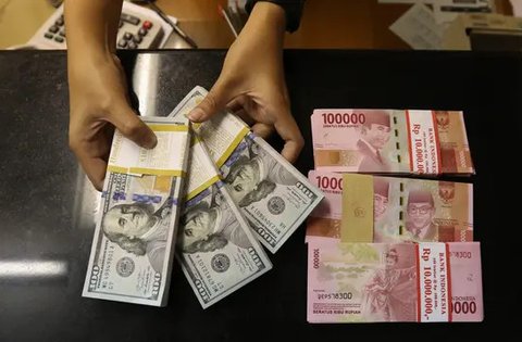 Pekerja menunjukan mata uang Rupiah dan Dolar AS di Jakarta, Rabu (19/6/2019). Nilai tukar rupiah terhadap dolar Amerika Serikat (AS) sore ini Rabu (19/6) ditutup menguat sebesar Rp 14.269 pe
