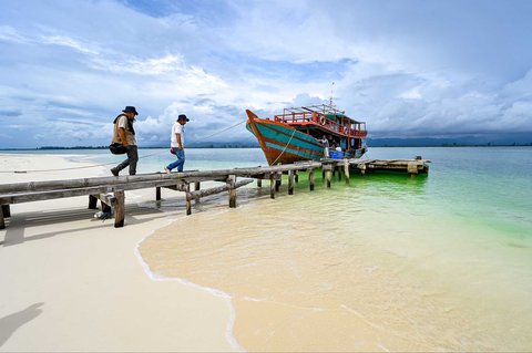 Pengunjung berjalan menuju perahu di Pulau Panjang, yang pernah menjadi sengketa perbatasan antara Aceh dan Sumatera Utara, di Singkil, provinsi Aceh Selatan, Rabu (12/11/2025).