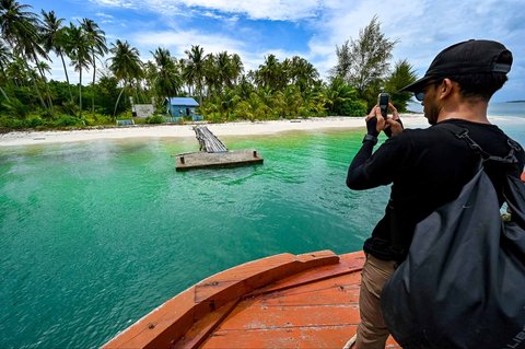 Pengunjung berjalan menuju perahu di Pulau Panjang, yang pernah menjadi sengketa perbatasan antara Aceh dan Sumatera Utara, di Singkil, provinsi Aceh Selatan, Rabu (12/11/2025).