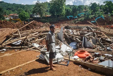 Warga berdiri di dekat rerutuhan rumah  akibat bencana tanah longsor di Desa Cibeunying, Majenang, Kabupaten Cilacap, Jawa Tengah, Senin (17/11/2025).