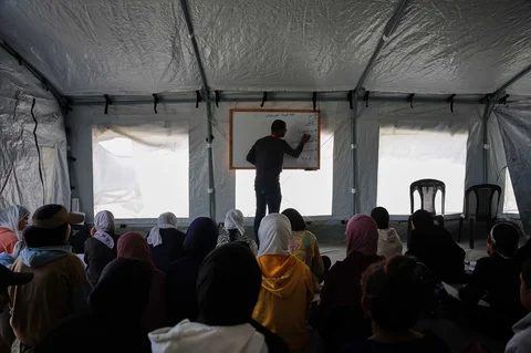 Siswa-siswi Palestina mengikuti kelas di dalam tenda yang didirikan di pantai Khan Younis, Jalur Gaza, Rabu (17/11/2025).