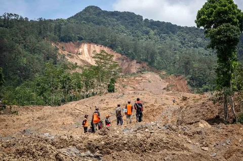 Para relawan penyelamat berdiri di lokasi tanah longsor di Desa Situkung, Banjarnegara, Jawa Tengah, Selasa (18/11/2025).