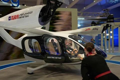 Seorang perempuan mengambil foto taksi udara Dubai yang dipamerkan di Dubai Air Show, Uni Emirat Arab, Selasa (18/11/2025).