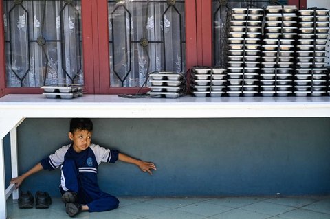 Siswa  bermain di bawah meja nampan Makanan Bergizi Gratis (MBG) di Sekolah Dasar Negeri 20 Banda Aceh, Aceh, Kamis (30/10/2025).