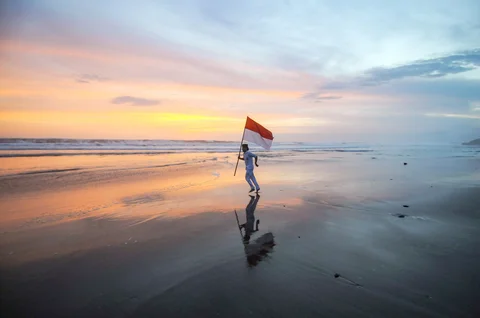 Pengunjung membuat konten media sosial  saat senja di  Pantai Pasut di Tabanan, Bali