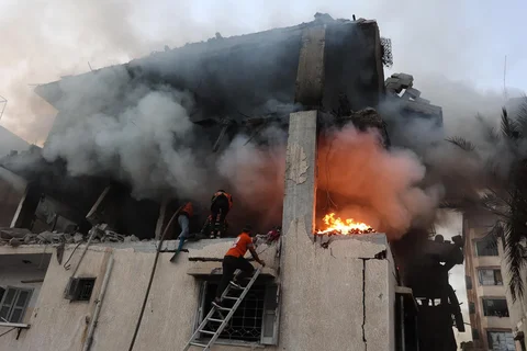 Personel pertahanan sipil memeriksa rumah yang terbakar akibat serangan udara Israel di Kota Gaza, Sabtu (22/11/2025).