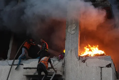 Personel pertahanan sipil memadamkan api rumah yang terbakar akibat serangan udara Israel di Kota Gaza, Sabtu (22/11/2025).