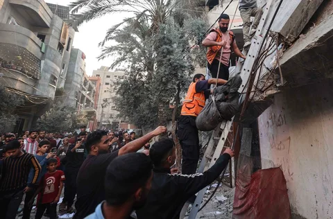 Personel Pertahanan Sipil Palestina mengevakuasi jenazah korban dari reruntuhan bangunan yang menjadi sasaran serangan udara Israel di kamp pengungsi Nuseirat di Jalur Gaza tengah, Sabtu (22/11/2025).