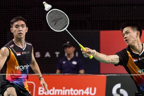 Pasangan ganda putra Indonesia Raymond Indra/Nikolaus Joaquin melakukan pengembalian bola ke arah pasangan ganda putra Indonesia Fajar Alfian/Muhammad Shohibul Fikri pada pertandingan final ganda putra turnamen bulu tangkis Australia Open di Sydney, Minggu (23/11/2025).