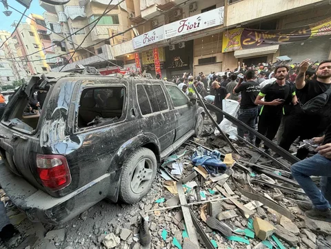 Warga berkerumun di lokasi serangan udara Israel yang menargetkan sebuah bangunan perumahan dan menewaskan kepala staf Hizbullah Haytham Tabtabai di kawasan Haret Hreik, Beirut, selatan, Minggu (23/11/2026).
