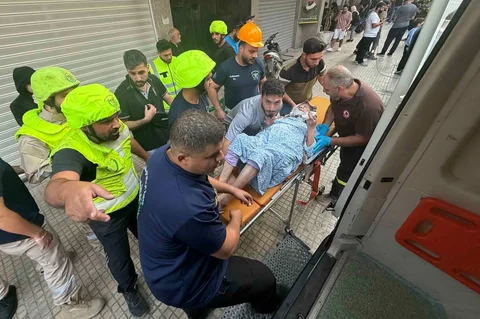 Tim penyelamat mengevakuasi seorang perempuan yang terluka dari lokasi serangan udara Israel yang menargetkan sebuah bangunan perumahan dan menewaskan kepala staf Hizbullah Haytham Tabtabai di kawasan Haret Hreik, Beirut, selatan, Minggu (23/11/2026).