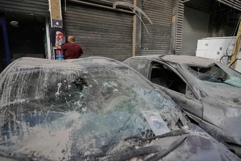 Seorang pria memasang poster mendiang Hassan Nasrallah di depan sebuah toko setelah serangan udara Israel yang menewaskan kepala staf Hizbullah di Hareit Hreik, Lebanon, Senin (2411/2025).