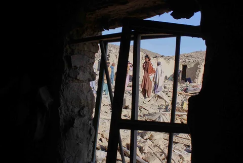 Warga Afghanistan berdiri di atas reruntuhan rumah yang hancur akibat serangan militer Pakistan di distrik Gurbaz, provinsi Khost, Afghanistan, Selasa (25/11/2025).
