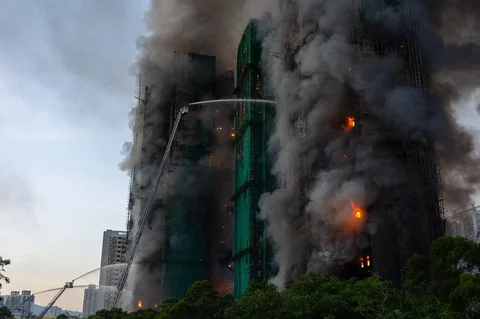 Petugas pemadam kebakaran berusaha memadamkam api di lokasi kebakaran di Wang Fuk Court, sebuah kompleks perumahan di distrik Tai Po, Wilayah Baru Hong Kong, Rabu (26/11/ 2025).