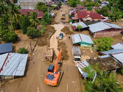 Sebuah ekskavator sedang membersihkan lumpur dari banjir bandang di jalan utama yang menghubungkan Aceh dan Sumatera Utara di Meureudu, Kabupaten Pidie Jaya, Provinsi Aceh, Jumat (28/11/2025).