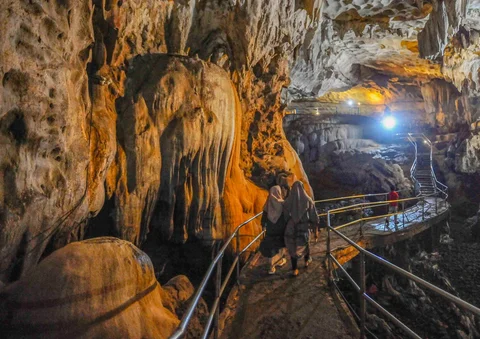 Pengunjung berjalan melewati jembatan beton dalam Goa Lowo di Watuagung, Trenggalek, Jawa Timur