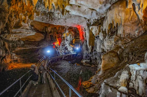 Pengunjung berjalan melewati jembatan beton dalam Goa Lowo di Watuagung, Trenggalek, Jawa Timur