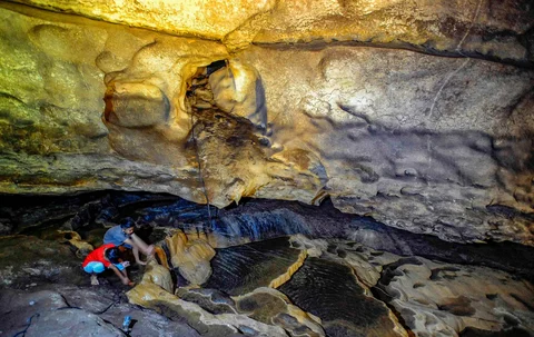 Anak-anak bermain air pada aliran sungai kecil dalam Goa Lowo di Watuagung, Trenggalek, Jawa Timur