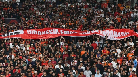 Suporter Persija membawa spanduk bertulisakan Indonesia Emas Bukan Indonesia Bekas, dalam mendukung pemerintah memberantas import pakaian bekas saat Laga pekan ke-14 BRI Super League