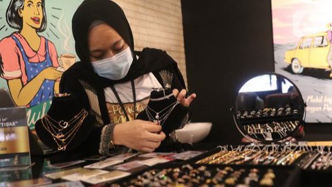 Pelanggan melihat perhiasan emas yang tersusun dalam etalase di Galeri 24, Jakarta, Selasa (13/9/2022). Selain emas batangan, Antam juga menjual bentuk lain seperti koin dinar, dirham, mau