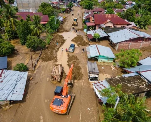 Warga berjalan melewati rumah-rumah yang rusak di sebuah desa yang terdampak banjir di Malalak, Sumatera Barat, Jumat 28 November 2025. Jelang akhir November 2025, bencana banjir bandang dan
