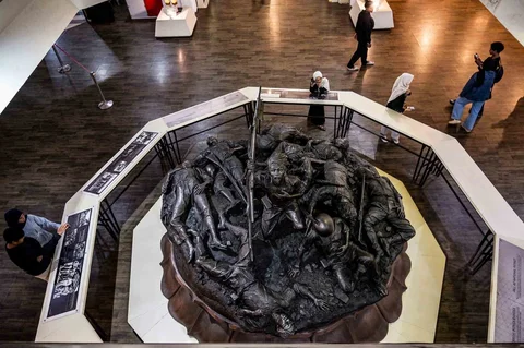 Pengunjung memperhatikan patung Pertempuran Surabaya dalam gelaran Malam di Museum 2025 di Museum 10 November, Surabaya, Sabtu (29/11/2025) malam.