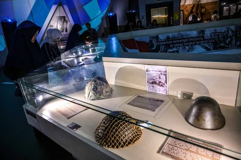 Pengunjung mengamati peralatan militer yang disita Indonesia dari pasukan Jepang, India Britania, dan Belanda dalam gelaran Malam di Museum 2025 di Museum 10 November, Surabaya, Sabtu (29/11/2025) malam.