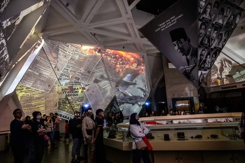 Pengunjung menyaksikan video imersif yang menggambarkan Pertempuran Surabaya yang terjadi pada bulan November 1945 dalam gelaran Malam di Museum 2025 di Museum 10 November, Surabaya, Sabtu (29/11/2025) malam.