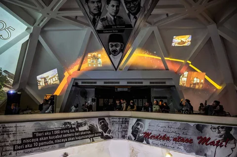 Pengunjung menyaksikan video imersif yang menggambarkan Pertempuran Surabaya yang terjadi pada bulan November 1945 dalam gelaran Malam di Museum 2025 di Museum 10 November, Surabaya, Sabtu (29/11/2025) malam.