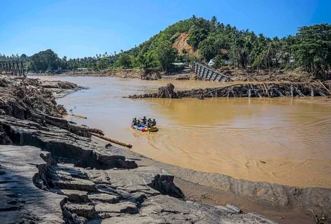 Petugas penyelamat berjalan melewati puing-puing saat mengevakuasi seorang warga desa yang sakit untuk dibawa ke rumah sakit terdekat di Bireuen, Provinsi Aceh, Sabtu (29/11/2025).