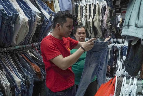 Pedagang melayani pembeli pakaian bekas yang dijual di Pasar Senen, Jakarta, Jumat (05/11/2025).