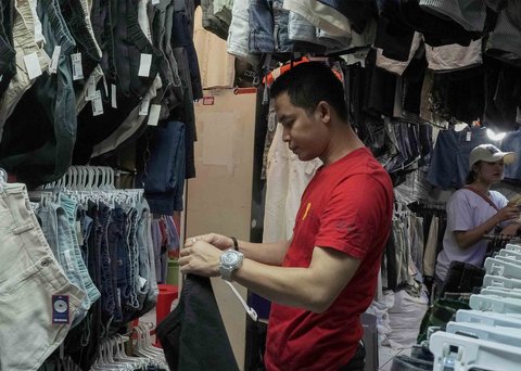 Pedagang menata pakaian bekas yang dijual di Pasar Senen, Jakarta, Jumat (05/11/2025).