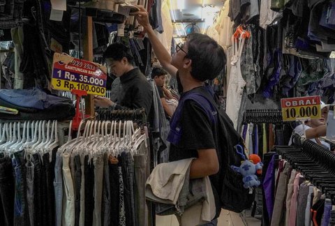 Pembeli memilih pakaian bekas bekas yang dijual di Pasar Senen, Jakarta, Jumat (05/11/2025).