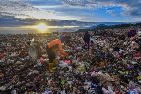 Warga mengumpulkan sampah plastik dengan latar belakang  Gunung Salak dan Gunung Gede-Pangrango di TPA Galuga, Bogor, Kamis (06/22/2025). Kementerian Lingkungan Hidup meminta seluruh TPA yang masih menggunakan sistem open dumping di wilayah Jabodetabek untuk segera melakukan capping atau penutupan tumpukan sampah guna mencegah pencemaran lingkungan dan penyebaran mikroplastik.