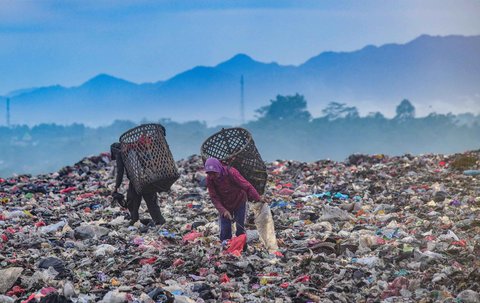 Warga mengumpulkan sampah plastik dengan latar belakang  keindahan perbukitan di TPA Galuga, Bogor, Kamis (06/22/2025). Kementerian Lingkungan Hidup meminta seluruh TPA yang masih menggunakan sistem open dumping di wilayah Jabodetabek untuk segera melakukan capping atau penutupan tumpukan sampah guna mencegah pencemaran lingkungan dan penyebaran mikroplastik.