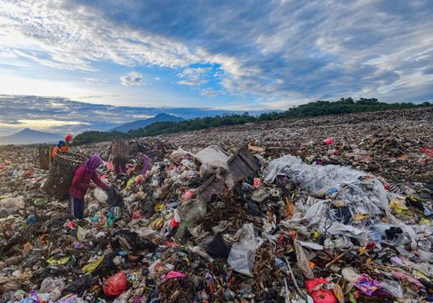 Warga mengumpulkan sampah plastik dengan latar belakang  Gunung Salak dan Gunung Gede-Pangrango di TPA Galuga, Bogor, Kamis (06/22/2025). Kementerian Lingkungan Hidup meminta seluruh TPA yang masih menggunakan sistem open dumping di wilayah Jabodetabek untuk segera melakukan capping atau penutupan tumpukan sampah guna mencegah pencemaran lingkungan dan penyebaran mikroplastik.
